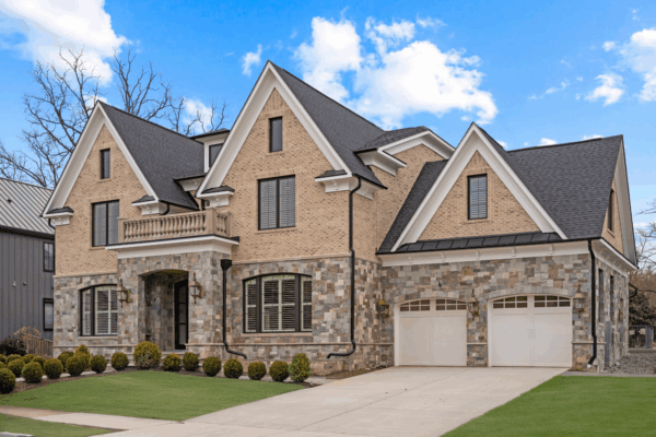Luxury custom home with stone and brick exterior, arched entryway, and two-car garage designed by Paradigm Homes in Northern Virginia.