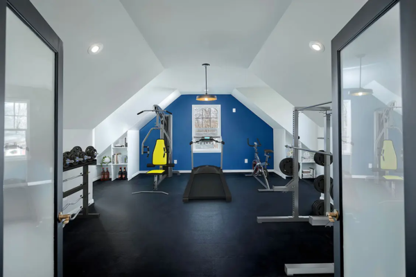Exercise room with equipment and blue accent wall
