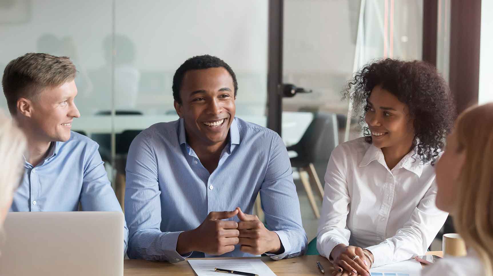 Group of smiling people meeting at a table