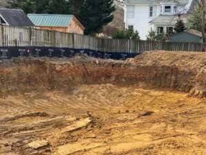 Exposed earth and soil layers in a freshly excavated lot for a new home build in a residential Arlington neighborhood.